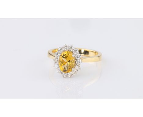 An 18ct yellow gold, citrine and diamond cluster ring, the 8 x 6.5mm. citrine, approx. 1.25ct, within a border of fourteen br