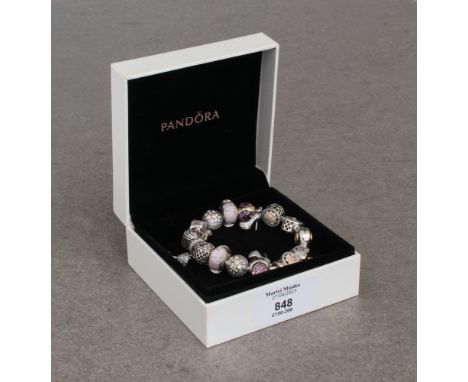 A Pandora bracelet with sixteen silver charms, in pink and cream tones, all set with enamel, glass or crystals, in a Pandora 