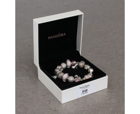 A Pandora bracelet with sixteen silver charms, in pink and cream tones, all set with enamel, glass or crystals, in a Pandora 