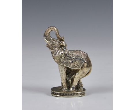 An Indian silver plated elephant paperweight, elephant with trunk up, and saddle blanket, raised on oval base, 4 ¾in. (12.2cm