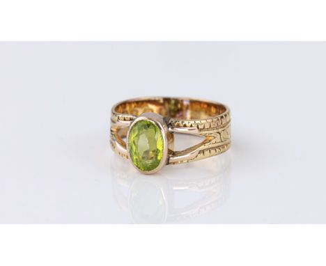 A vintage 18ct yellow gold and peridot ring, hallmarked London 1935, the 8 x 5.5mm. oval cut peridot in a scalloped rub-over 