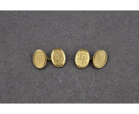 A pair of 18ct gold cufflinks, hallmarked EAP, Birm. 1925, oval with 'watered' engine turned decoration. (2)* Presentation in
