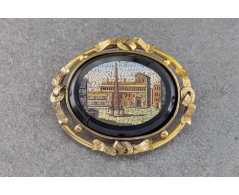 A Victorian rolled gold and micro mosaic brooch, the oval micro mosaic depicting a classical architectural scene, within a bl