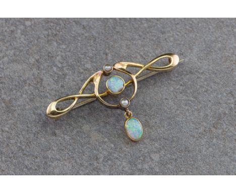 An Edwardian 15ct gold and opal bar brooch, in the Art Nouveau style, the open scrollwork brooch set with a central round cab