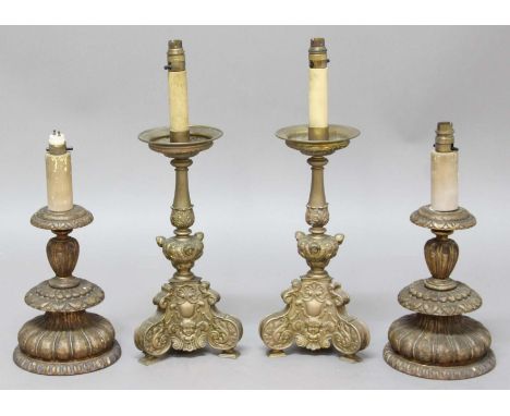 PAIR OF GILT METAL CANDLESTICKS, the pair of drip trays above a foliate column and tripod base cast with scrolls and masks, f