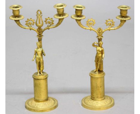 PAIR OF EMPIRE STYLE GILT BRASS CANDELABRA, 19th century, a classical figure standing before a column, on a fish scale base a