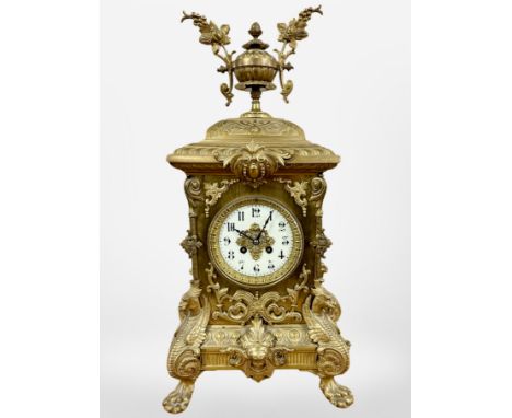 An impressive 19th century gilt metal eight day mantel clock, raised on lion paw feet, striking on a bell, with pendulum and 