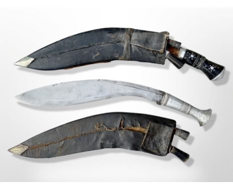 Two kukri knives in sheathes, one with aluminium grip, longest 44cm. CONDITION REPORT: One example rusted and seized in scabb