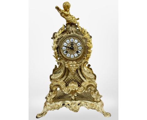 A 19th century Rococo Revival gilt metal eight day mantel clock, surmounted by a cherub, striking on a bell, with pendulum an