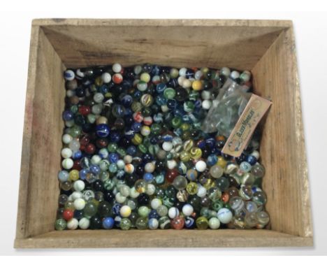 A pine crate containing a large quantity of vintage glass marbles 