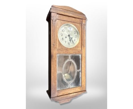 An early 20th century Continental oak eight day wall clock with silvered dial, height 85 cm