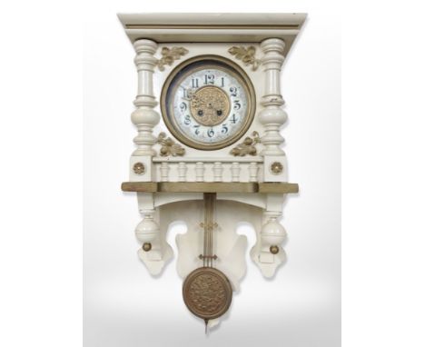 A Continental cream and gilt eight day wall clock with enamelled dial, pendulum, height 67 cm
