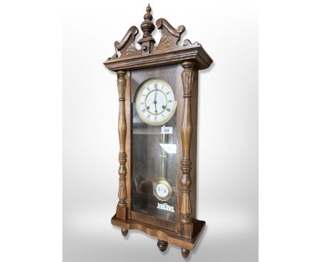 A Hermle oak eight day wall clock with enamelled dial, height 85 cm