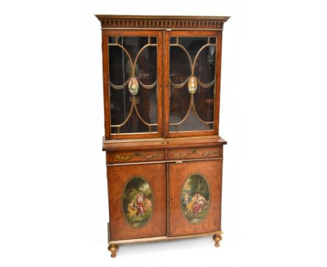 A good Regency satinwood and painted bookcase on cupboard, the moulded pediment above two glazed doors, each centred with an 