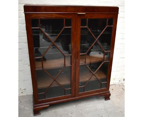 An early 20th century mahogany bookcase, the pair of astragal glazed doors, enclosing an arrangement of two glass and two woo