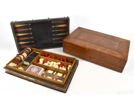 An oak cased games compendium housing a white and stained ivory chess set, height of king 5.5cm (some pieces af), draughts, d