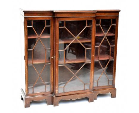 A late 19th century breakfront bookcase, the three astragal glazed doors enclosing adjustable shelves, raised on bracket feet