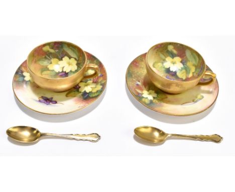 ROYAL WORCESTER; a pair of hand painted cabinet cups and saucers, signed 'Twin', each painted with violets and primroses, the