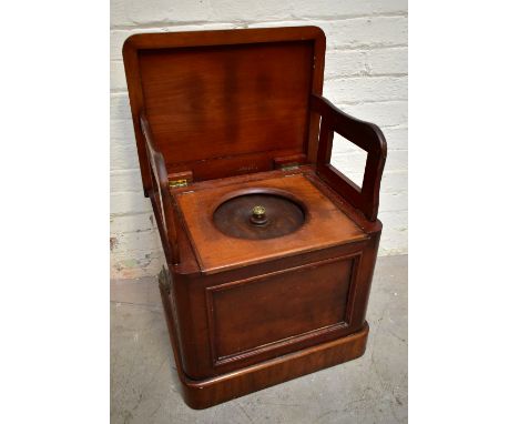 A Victorian mahogany box commode, the hinged top enclosing two folding arms and a circular lid above a panelled front on plin