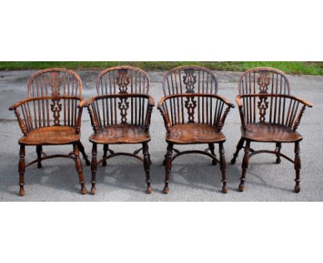 A near set of four 19th century yew wood and ash Windsor chairs, the stick hooped backs with pierced splats and scrolling arm