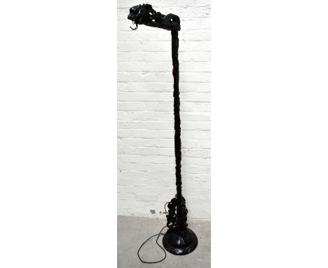 A Chinese carved rosewood standard lamp in the form of a mythical beast, height 178cm (lacking fitting).