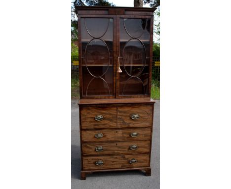 An early 19th century mahogany secretaire bookcase with moulded cornice above two astragal glazed doors enclosing adjustable 