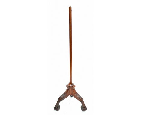 A 20th century carved hardwood standard lamp, raised on elaborately carved ball and claw feet, height 154cm.