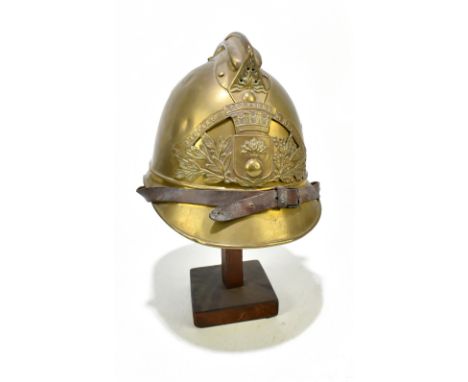 A French fireman's brass helmet with applied badge inscribed 'Sapeurs Pompiers De Neuille Le L.', presented on wooden stand.P