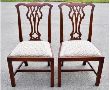 A set of four 20th century mahogany Chippendale style dining chairs, with drop-in seats, raised on block supports, indistinct