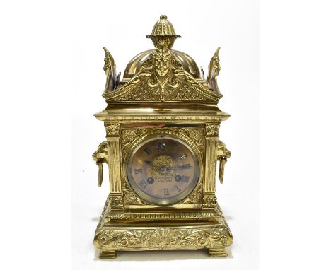 A 19th century gilt brass mantel clock with pineapple finial above cast scrolling and mask head handles and detail surroundin