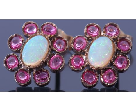 Pair of opal and ruby cluster earrings, the centre with a cabochon opal bezel set between 8 small round rubies, post-fittings