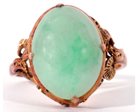 Modern jade ring of oval cabochon shape, cardinal set in a scroll pierced mount, stamped 22K, size Q