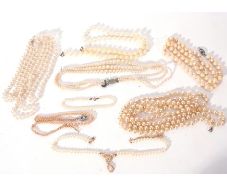 A blue bag containing various simulated pearl necklaces