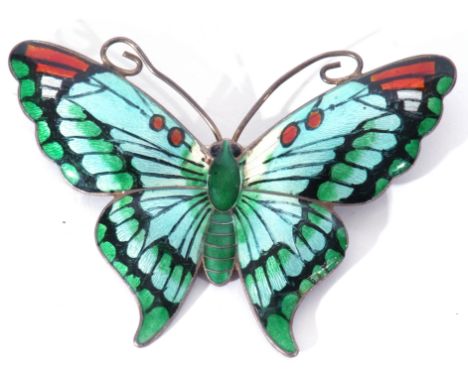 Silver and enamel butterfly brooch, the outstretched wings and body decorated in green, red and blue translucent enamels (sma