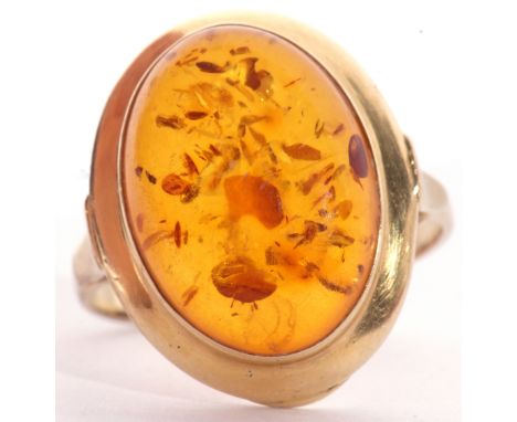 Modern yellow metal and amber dress ring, the oval cabochon amber centre 16 x 12mm, bezel set in a plain polished mount, size