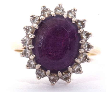 18ct gold, amethyst and diamond cluster ring, the large central oval faceted amethyst 12 x 10mm, surrounded by small single c