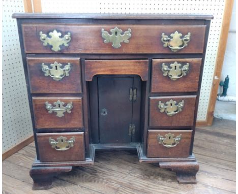 A George III mahogany Knee hole desk. Circa 1760. Fitted with a central drawer above a recessed cupboard and flanked by sets 