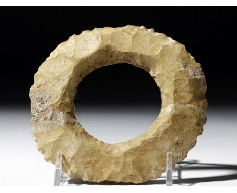 Pre-Columbian, Mayan Territories, ca. 600 to 900 CE. A round, caramel-yellow stone ring with sharp, widely-spaced serrated ed
