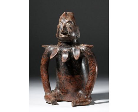 Pre-Columbian, Western Mexico, Colima, ca. 300 BCE to 300 CE. An impressive redware sculpture representing a seated shaman, w