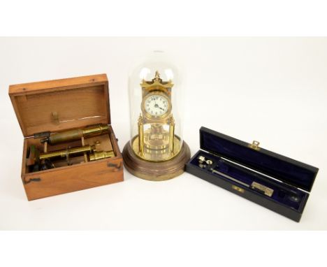 Brass perpetual clock in glass dome, students microscope and measuring wheel .     