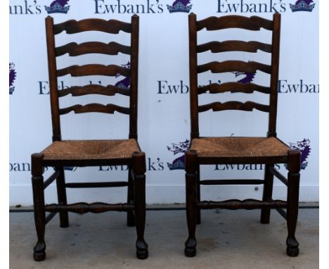 Oak dining table and a set of six oak ladder back dining chairs .     