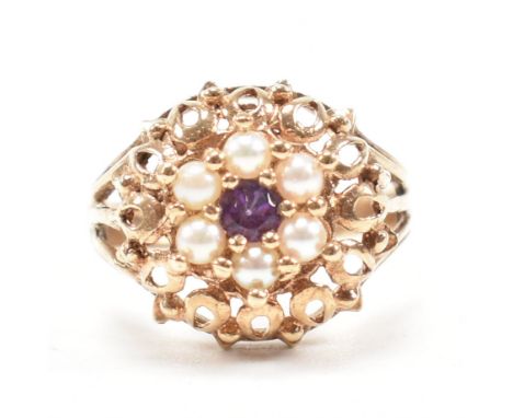 A hallmarked 9ct gold amethyst and pearl cluster ring. The ring set with a central round mixed cut amethyst framed by half pe