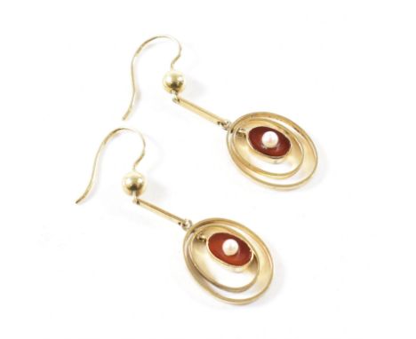 A pair of Edwardian carnelian and pearl drop earrings. The earrings having a central suspended pendant panel of milgrain set 