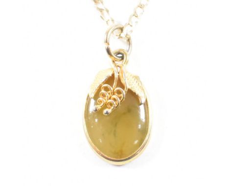 A hallmarked 9ct gold chain strung with a jade pendant. The necklace strung with a carved jade fruit having a plated mount st