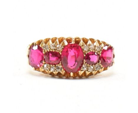 An Antique hallmarked 18ct yellow gold, synthetic ruby and diamond cluster ring. The ring having a central oval cut ruby flan