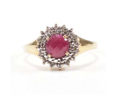 A gold ruby and diamond cluster ring. The ring set with a&nbsp; with central ruby surrounded by diamonds.&nbsp; Marked 375 te