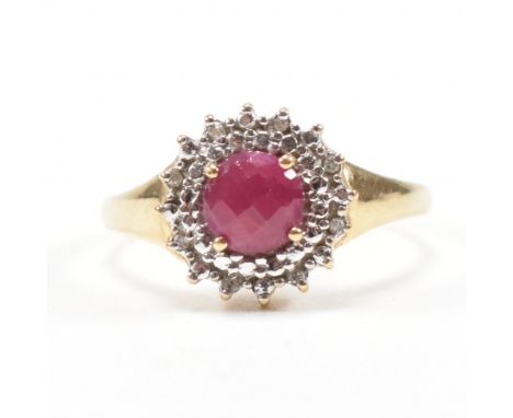 A gold ruby and diamond cluster ring. The ring set with a&nbsp; with central ruby surrounded by diamonds.&nbsp; Marked 375 te