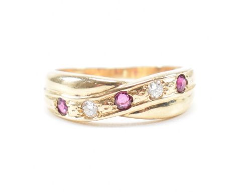 A hallmarked 9ct yellow gold, ruby and diamond crossover ring. The ring set with alternating round cut rubies and diamonds to