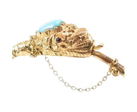 A 19th century yellow metal and turquoise serpent bangle. The bangle having a coiled band to ouroboros serpent's head set wit