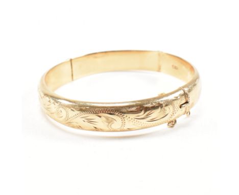 A vintage hallmarked 9ct yellow gold bangle bracelet. The hinged bangle having etched scrolling pattern to the obverse united